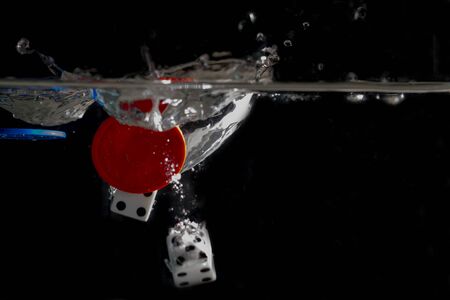 Dice and Poker chips splashing in the water