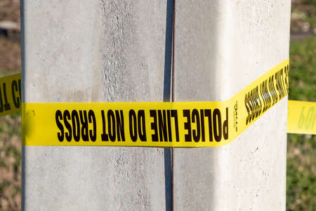Police line tape around a pollの写真素材