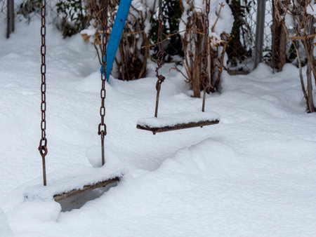 Swing in a park covered with snowの写真素材