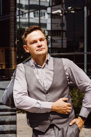 Handsome man in sunlight. Man on cityscape and buildings with reflections of city. Businessman in...