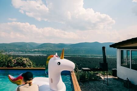 SIBERIA, RUSSIA - JULY 19: Girl sitting near inflatable unicorn