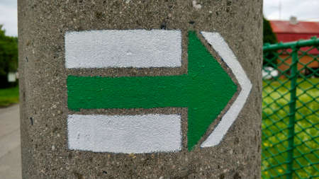 Green tourist direction mark on villages pole.
