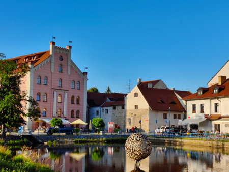 Ceske Budejovice, Czech Republic - July 12, 2021: Beautiful riverbank of historical town Ceske Budejovice with pink hotel building which was a warehouse in the middle-ages.のeditorial素材