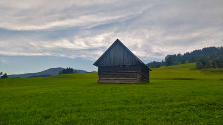 Pruggern, Austria - August 15, 2021: Small wooden barn in the middle of the grassland in the alpine area.のeditorial素材