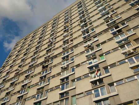 Warsaw, Poland - August 29, 2021: Frontage of old communist style block of flats seen from the bottom up to the sky in Warsaw.のeditorial素材