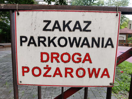 Warsaw, Poland - August 29, 2021: A label in Polish saying "No parking fire line". The label is fixed on the metal fence.のeditorial素材