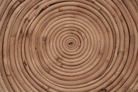 A decorative wooden bowl made of bamboo twigs seeing from the top. The twigs are banded into spiral.