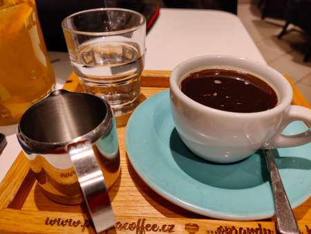 Pilsen, Czech Republic - December 20, 2021: Serving of coffee with water on the wooden board.のeditorial素材