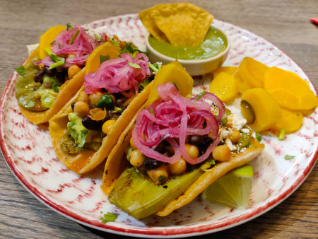 Maxican tacos with opuntia and nachos with quacamole served on a decorative plate.
