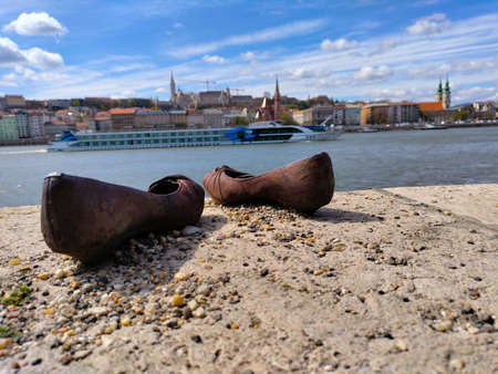 Memorial of killed Jews during the Second World War on the edge of the Danube river with Fisherman's bastion in the background.のeditorial素材