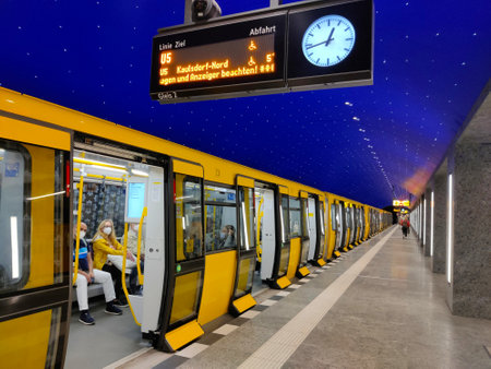 Berlin, Germany - July 6, 2022: Platform of an modern Berlin metro station with yellow train with opened doors waiting for passengers to get in.のeditorial素材