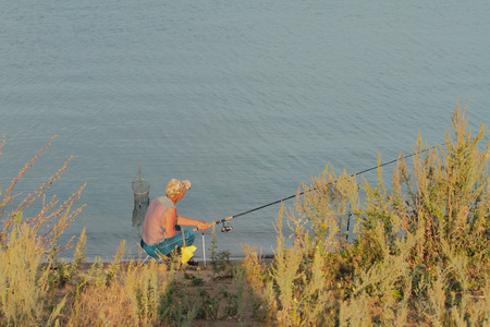 Fisherman on river bankの写真素材