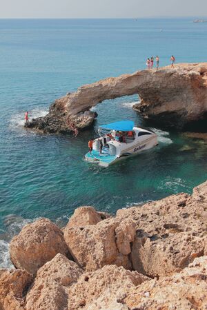 Agia Napa, Cyprus - Oct 26, 2019: Walking boat next to rock arch