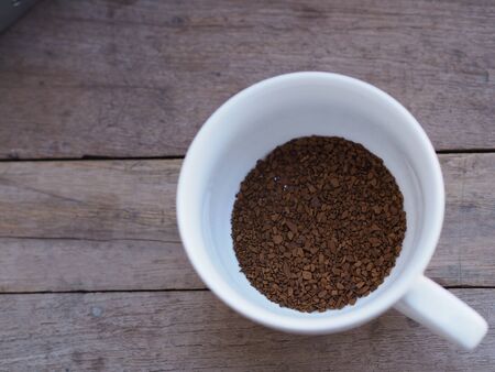 Instant coffee put in white mug on wooden table.の写真素材