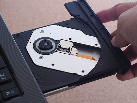 Hand is closing the laptop DVD tray.