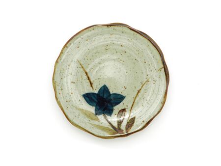 Empty circle ceramic plate with a brown rim and flower pattern isolated on a white background. Japanese style, used for serving, View from abvoe.の写真素材