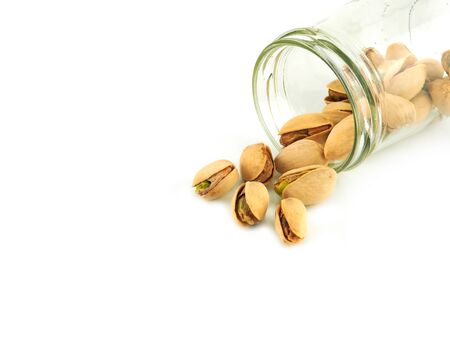 Pistachios in a bottle isolated on a white background. High Vitamin B6 and antioxidants. Low in calories yet high in protein.の写真素材