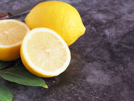 Half of fresh lemon with leaves on drak grey background with copy space. High vitamin C, which helps control weight and Reduce Cancer risk.の写真素材