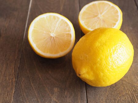 Fresh lemon and half on wooden background with copy space. High vitamin C, which helps control weight and Reduce Cancer risk.の写真素材