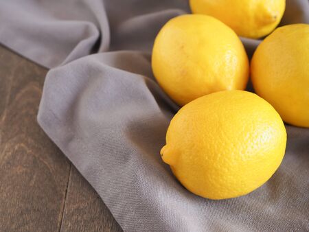 Group of fresh lemon on grey fabric background, with copy space. High vitamin C, which helps control weight and Reduce Cancer risk.の写真素材