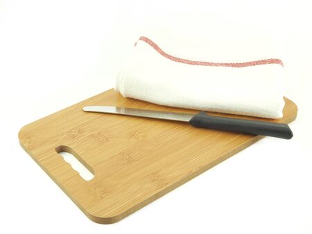 Knife, green napkin or kitchen towel on cutting board isolated on a white background.の写真素材