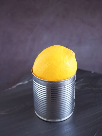 Lemons in a tin can put on a black stone and have a dark grey background is a good source of Vitamin C, which helps control weight and Reduce Cancer risk.の写真素材