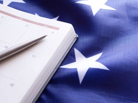 The pen point to number 4 in a diary, put on American flag background.