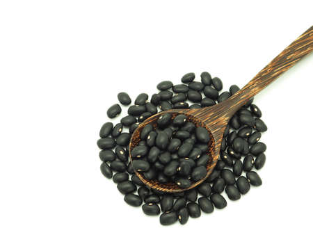 Black gram (vigna mungo) in a wooden spoon isolated on white background. High vitamins and iron.の写真素材