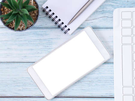 Blue workplace desk table with smartphone and notebook, Top view with copy space for text or app. Business education concept.の写真素材