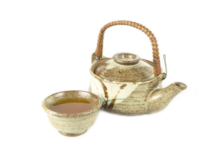 Brown clay teapot and teacup isolated on a white background. Asian food concept, space for text.の写真素材