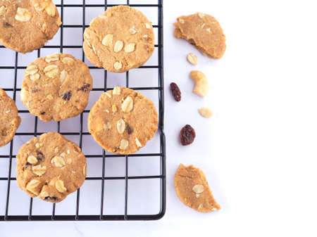 Healthy homemade oat cookies on a wire rack over marble table. Fresh from the oven, copy space.