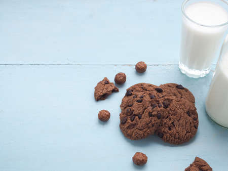 Homemade double chocolate chip cookies on blue wooden background with glass of milk. Copy space.の写真素材
