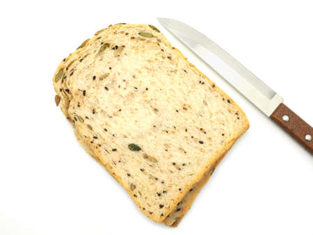 Fresh homemade slice of whole wheat bread  with knife isolated on a white background. Top view.