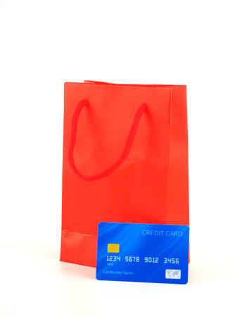 A credit card and a red paper bag isolated on a white background.の写真素材