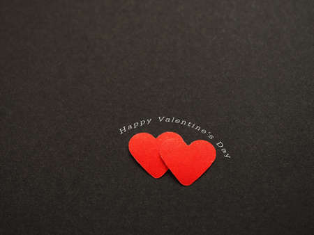 Red hearts with the word "happy valentine's day" on black paper background. The concept for love, greeting card, poster, Space for your text.の写真素材