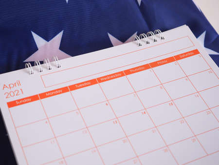 Calendar show page April 2021 focus no.1 over American flag backdrop.の写真素材