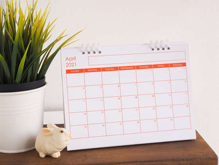 Calendar show page April 2021 decorated with rabbits and trees on wooden background.の写真素材