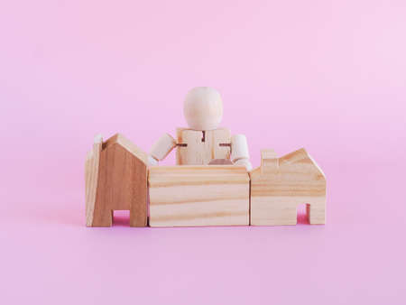 Wooden house and block, the doll on pink background. The concept investment, financial, New normal.の写真素材