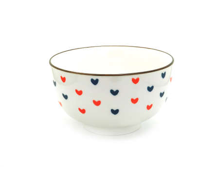 White ceramic bowl with heart-shaped pattern isolated on a white background. Use for home or restaurant, food design. Kitchen accessory.の写真素材