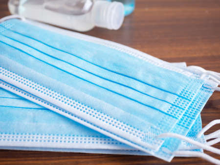 Close up, Medical face mask on brown wooden background. Concept of coronavirus outbreak and pollution. New normal.の写真素材