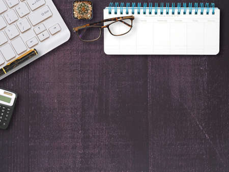 Flat lay of office wooden desktop with blank monthly notebook and eyeglasses with stationery equipment and cactus. Top view with space for text. Business and education concept.の写真素材