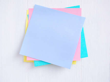 Sticky note ( Post-it) stack on a white wooden. Blank space for text and template for your message.