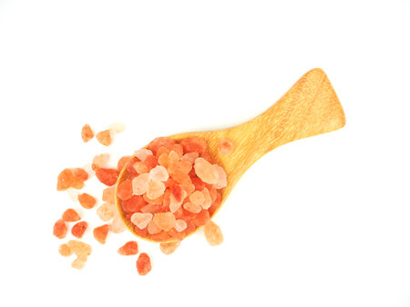 Flat lay, Top view, of himalayan pink salt in wooden spoon isolated on a white background.の写真素材