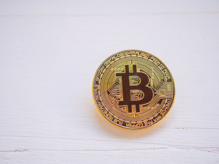 Close up, Golden shiny bitcoin cryptocurrency on white wooden. Business electronic money concept.の写真素材