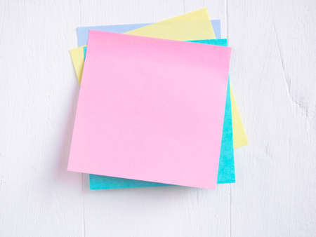 Sticky note stack on a white wooden. Blank space for text and template for your message.の写真素材