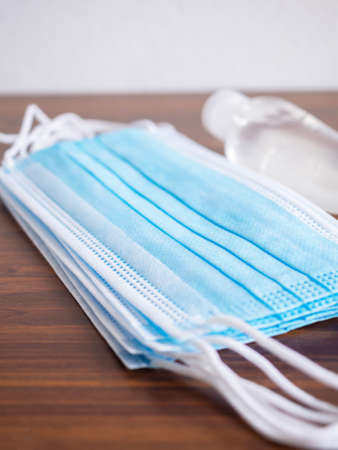 Close up, Medical face mask on brown wooden background. Concept of coronavirus outbreak and pollution. New normal.の写真素材