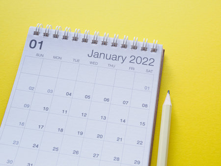 January 2022 calendar page and pencil on yellow paper background, blank for your text.の写真素材