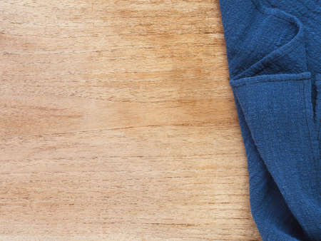 Top view, close-up of blue fabric or napkin on wooden table background. Concept kitchen utensils and tableware. Top view, flat lay with copy space.の写真素材