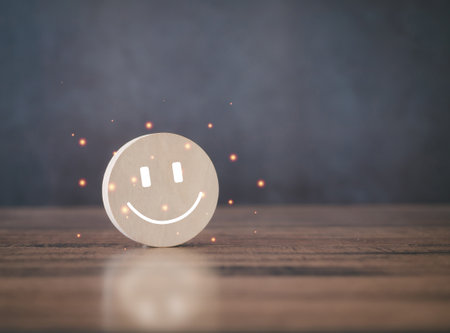 Circle wooden block with smiley icon on brown table. Satisfaction Rating Concept.の写真素材