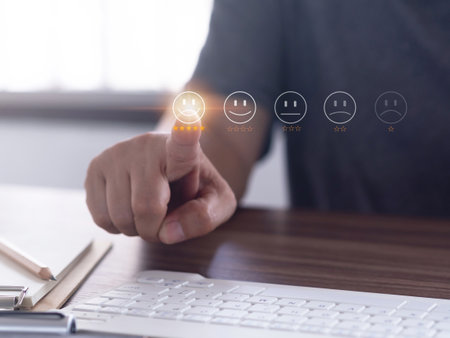 Customer touching the virtual screen on the happy smiley face icon sends feedback to service experience in the office or home. Customer service and satisfaction survey rating Concept.の写真素材
